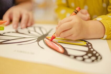Child coloring with crayons as a creative after-school activity for kids