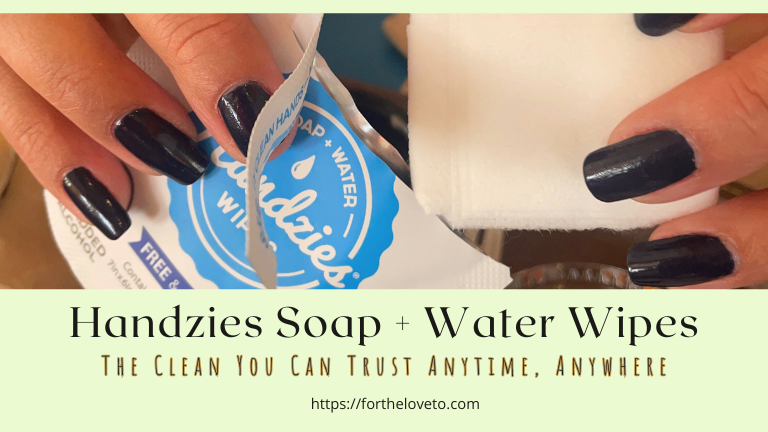 Hand pulling a wipe from Handzies Soap + Water Wipes pack, showing the gentle and convenient design