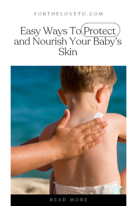 Hand applying  protective cream to the back of a baby boy that is sitting with an ocean background. 