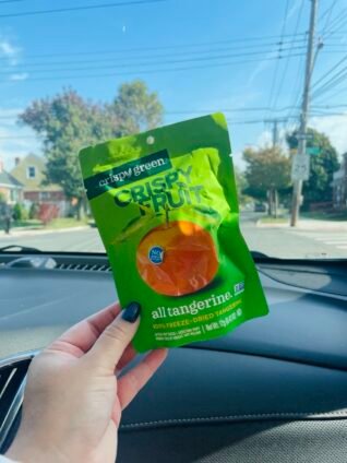 Crispy Green’s freeze-dried fruit snack pack held in hand, showcasing its portability and convenience for a healthy on-the-go snack