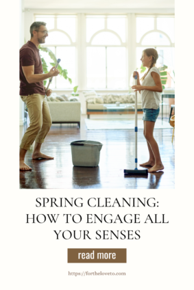 A father and daughter smiling and enjoying spring cleaning together in a sunlit home, with a mop and bucket in the foreground.