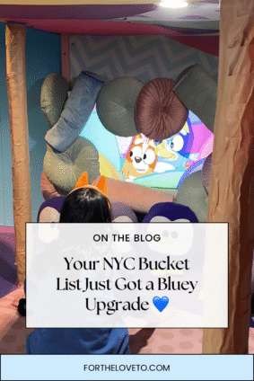 Child watching a Bluey episode while sitting inside a cozy, colorful pillow fort at the Bluey immersive experience in NYC.