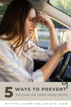 A woman in the driver’s seat rubbing her eyes in exhaustion, highlighting the struggle of fatigue during a long road trip.