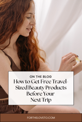 A woman with red hair smiling while applying beauty product from a travel-sized bottle. Text overlay reads: How to Get Free Travel-Sized Beauty Products Before Your Next Trip.