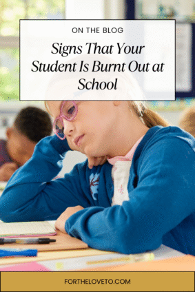 Girl in a classroom with glasses resting her head on her arm, appearing fatigued and unmotivated, highlighting signs of student burnt out at school.