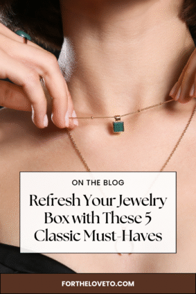 Woman holding a delicate gold necklace with a green gemstone pendant. Text overlay reads “Refresh Your Jewelry Box with These 5 Classic Must-Haves.” Ideal for a fashion or lifestyle blog about jewelry styling and everyday elegance.