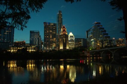 Austin skyline at night reflecting over the water during a family vacation in Austin TX.