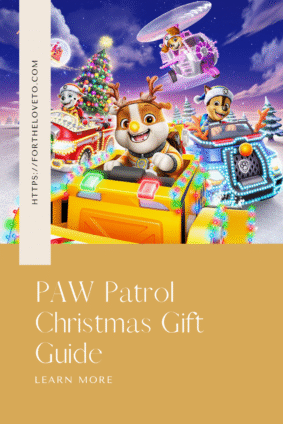 Colorful PAW Patrol Christmas scene featuring Rubble, Chase, Skye, and Marshall in festive holiday vehicles with Christmas lights and a decorated tree — promotional artwork for A PAW Patrol Christmas.