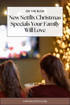 Two kids sitting together and watching new Netflix Christmas specials with holiday lights in the background, featured in a family holiday streaming guide.