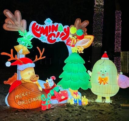 Colorful LuminoCity entrance display with glowing reindeer, Christmas tree, and festive lights welcoming visitors to the holiday light festival.