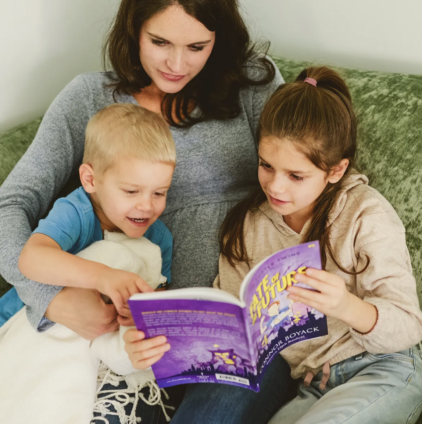 Mom reading with her kids on the couch during a cozy holiday reading time