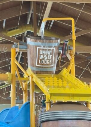 Great Wolf Lodge indoor water park splash zone with giant tipping bucket and slides, one of the main attractions for kids and families.