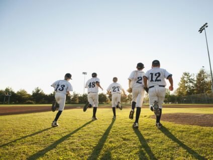 Children running onto a baseball field during youth activities, building teamwork, confidence, and lifelong memories through sports.