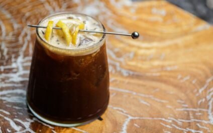 Glass of iced coffee with fresh lemon twists inspired by creative coffee ideas.