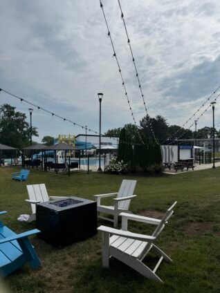 Outdoor pool, water slide, and fire pit area at the Dutch Wonderland Inn, a family-friendly hotel near Dutch Wonderland in Lancaster.