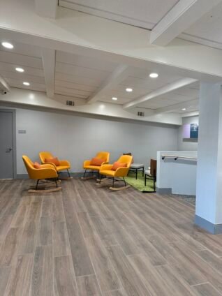 Bright and updated lobby seating area featured in this Spark by Hilton Lake George Outlets Review, showcasing comfortable lounge chairs and modern décor.