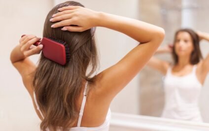 Woman brushing her hair as part of her hair care routine
