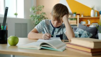 Child doing homework at home as part of an after school routine for kids