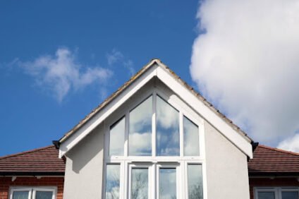 Family home roofline beneath a cloudy sky, highlighting ways to protect your home from storm damage.