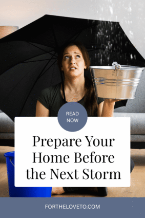Woman holding a bucket under an umbrella inside a leaking home, illustrating how to protect your home from storm damage.