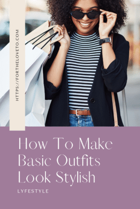 Woman styling a striped shirt with jeans, a black blazer, sunglasses, and a belt to make basic outfits look stylish