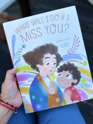 Hand holding What Will I Do If I Miss You?, a picture book about a child coping with missing a parent.